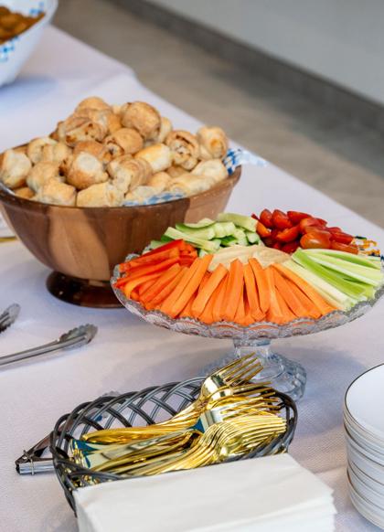 A crudité platter with dips alongside a tray of warm bourekas