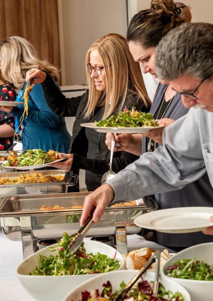 Guests helping themselves to salads and hot dishes at an Eisenberg's catered buffet